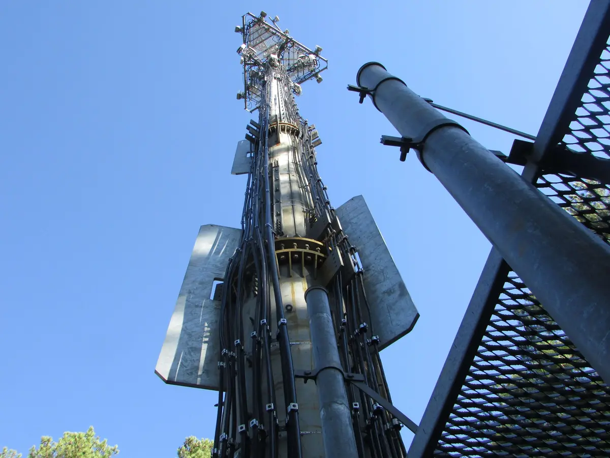 A telecom monopole with antenna mounts, seen from below
