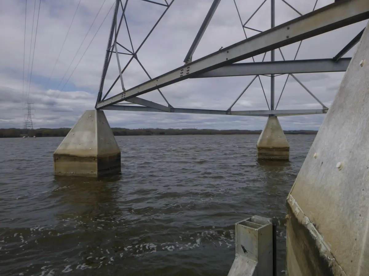 Transmission line towers standing on pile caps in open water