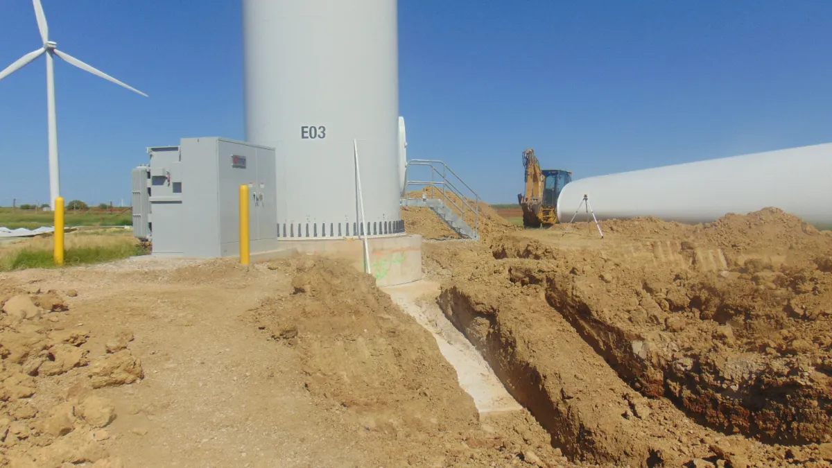A wind turbine base with a trench excavated beside its foundation