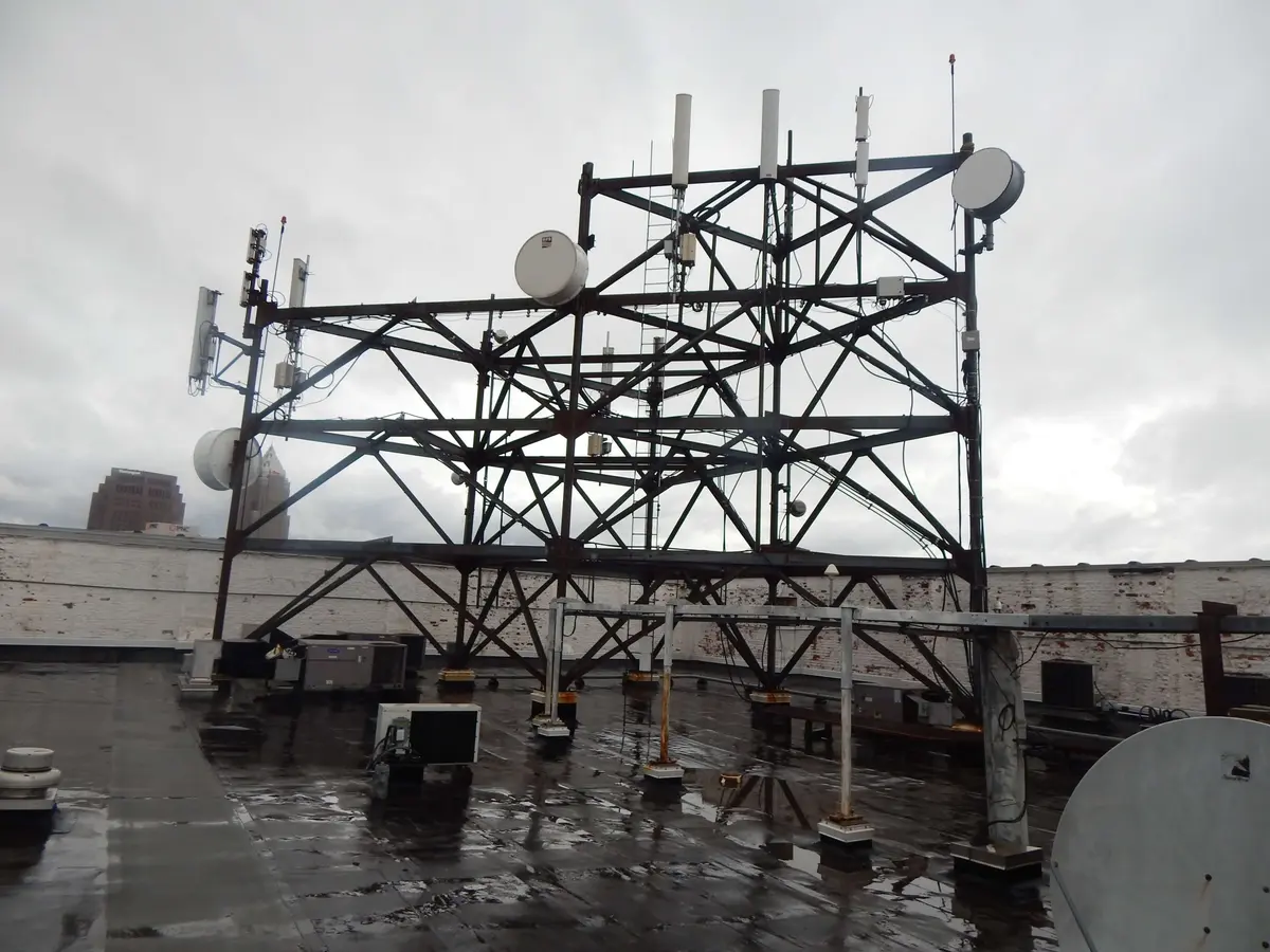A rooftop telecom structure with antennas and dishes